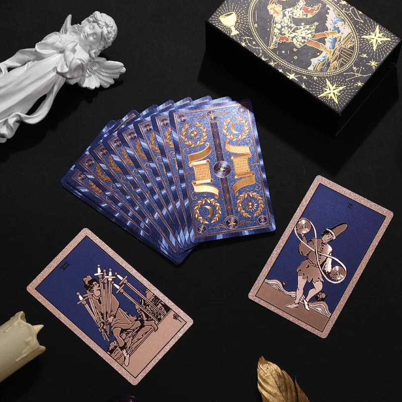 Blue and gold foil Rider-Waite-Smith tarot deck fanned on a black background with gift box