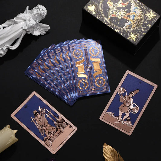 Blue and gold foil Rider-Waite-Smith tarot deck fanned on a black background with gift box