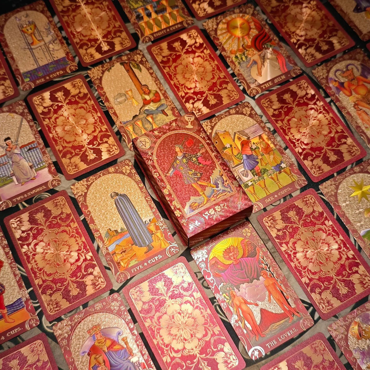 Crimson and gold floral tarot cards with matching illustrated presentation box