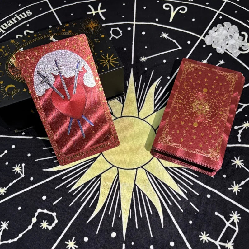 Red gold foil tarot deck with Three of Swords card on astrology cloth