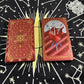 Red gold foil tarot deck showing Three of Swords card and ornate back