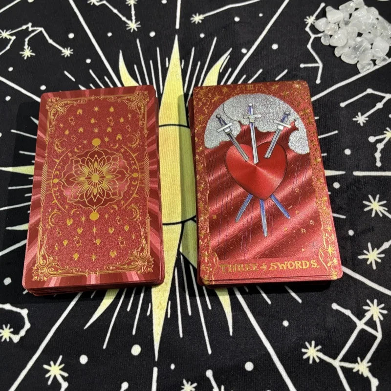 Red gold foil tarot deck showing Three of Swords card and ornate back